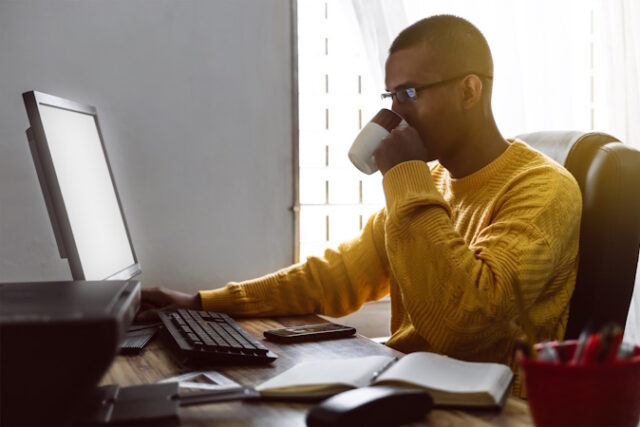 latin american young adult man have a cup of coffee while working on his desktop computer. https://www.vecteezy.com/photo/42233027-latin-american-young-adult-man-have-a-cup-of-coffee-while-working-on-his-desktop-computer