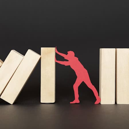 red-paper-person-struggling-while-holding-wooden-pieces