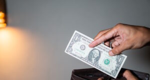 https://www.vecteezy.com/photo/46779179-person-holding-a-one-dollar-bill-and-a-wallet-with-coins
