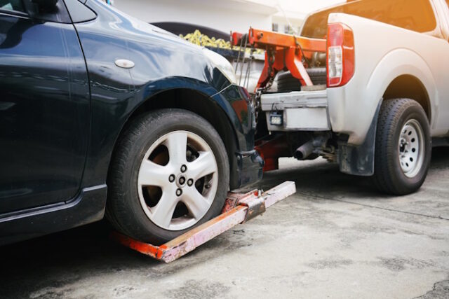 Tow truck picking up and towing old broken down car on a roadside https://www.vecteezy.com/photo/6965666-tow-truck-picking-up-and-towing-old-broken-down-car-on-a-roadside