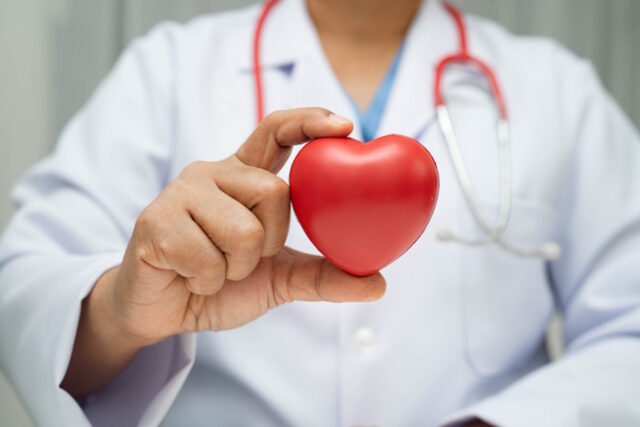 Asian woman doctor holding red heart for health in hospital. https://www.vecteezy.com/photo/51692525-asian-woman-doctor-holding-red-heart-for-health-in-hospital