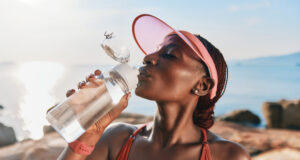 https://www.vecteezy.com/photo/51234207-a-fit-woman-in-a-cap-enjoying-water-from-a-bottle-with-a-serene-ocean-background-and-a-warm-sunny