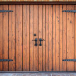 Classic wooden doors with metal hardware in a charming brick exterior at dusk