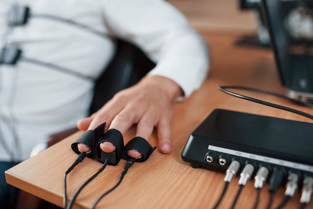 Hand with electrodes on fingers is on the table. Suspicious man passes lie detector in the office. Asking questions. Polygraph test https://www.vecteezy.com/photo/15196997-hand-with-electrodes-on-fingers-is-on-the-table-suspicious-man-passes-lie-detector-in-the-office-asking-questions-polygraph-test