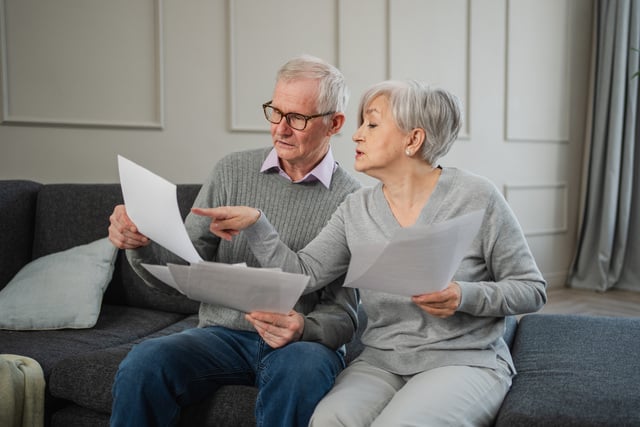 Sad tired disappointed middle aged senior couple sit with paper document. Unhappy older mature man woman reading paper bill managing bank finances calculating taxes planning loan debt pension payment. https://www.vecteezy.com/photo/37319308-sad-tired-disappointed-middle-aged-senior-couple-sit-with-paper-document-unhappy-older-mature-man-woman-reading-paper-bill-managing-bank-finances-calculating-taxes-planning-loan-debt-pension-payment