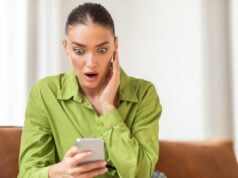 https://www.vecteezy.com/photo/50855251-a-young-woman-wearing-a-striking-green-blouse-is-seated-indoors-with-an-expression-of-surprise-and-disbelief-as-she-looks-at-her-smartphone-her-eyes-are-wide-and-her-hand-is-pressed-to-her-cheek