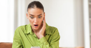 https://www.vecteezy.com/photo/50855251-a-young-woman-wearing-a-striking-green-blouse-is-seated-indoors-with-an-expression-of-surprise-and-disbelief-as-she-looks-at-her-smartphone-her-eyes-are-wide-and-her-hand-is-pressed-to-her-cheek