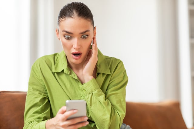 https://www.vecteezy.com/photo/50855251-a-young-woman-wearing-a-striking-green-blouse-is-seated-indoors-with-an-expression-of-surprise-and-disbelief-as-she-looks-at-her-smartphone-her-eyes-are-wide-and-her-hand-is-pressed-to-her-cheek