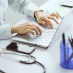 Asian female doctor working with computer in office