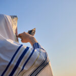 Jewish man blowing the Shofar rams horn on Rosh Hashanah and Yom Kippur day.