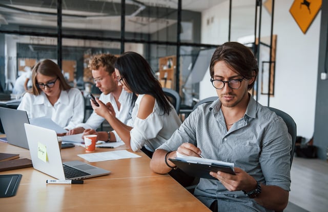 Guy in glasses in front of his employees. Young business people in formal clothes working in the office https://www.vecteezy.com/photo/15227028-guy-in-glasses-in-front-of-his-employees-young-business-people-in-formal-clothes-working-in-the-office