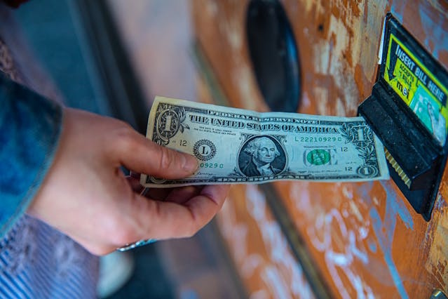 https://www.pexels.com/photo/a-person-inserting-a-dollar-bill-in-a-machine-4921882/