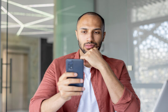 https://www.vecteezy.com/photo/69143619-man-engaged-with-smartphone-in-contemporary-office