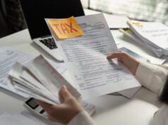 https://www.vecteezy.com/photo/57594277-person-analyzing-tax-paperwork-and-using-a-calculator-for-financial-calculations