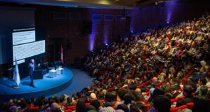 https://unsplash.com/photos/speaker-presenting-to-large-audience-in-auditorium-_96edJ8IVC4