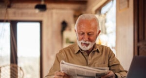 https://www.vecteezy.com/photo/79515719-senior-man-enjoying-at-home-reading-a-newspaper-while-having-a-laptop-in-front-of-him
