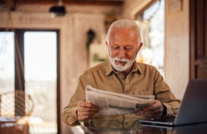 https://www.vecteezy.com/photo/79515719-senior-man-enjoying-at-home-reading-a-newspaper-while-having-a-laptop-in-front-of-him