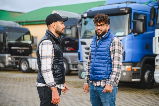 Truck drivers discussing logistics in truck parking lot https://www.vecteezy.com/photo/74597052-truck-drivers-discussing-logistics-in-truck-parking-lot