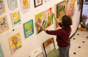 https://unsplash.com/photos/a-woman-hangs-paintings-on-a-gallery-wall-c0segOndxpE