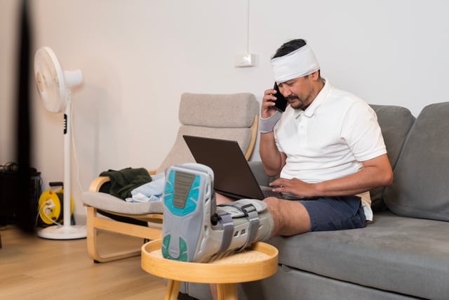 Injured man with leg brace and head bandage using laptop and tal https://www.vecteezy.com/photo/73680948-injured-man-with-leg-brace-and-head-bandage-using-laptop-and-talking-on-phone-during-home-recovery-time