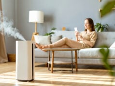 How to Improve Indoor Air Quality in Florida Homes https://www.vecteezy.com/photo/73915570-a-woman-sitting-on-a-couch-in-front-of-a-white-air-purifier