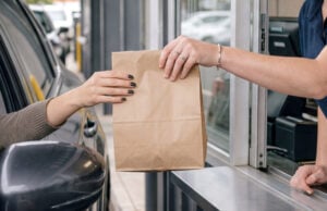 Drive-Thrus Led To The Installation Of Cup Holders In Vehicles https://www.vecteezy.com/photo/81926305-handing-over-a-takeout-bag