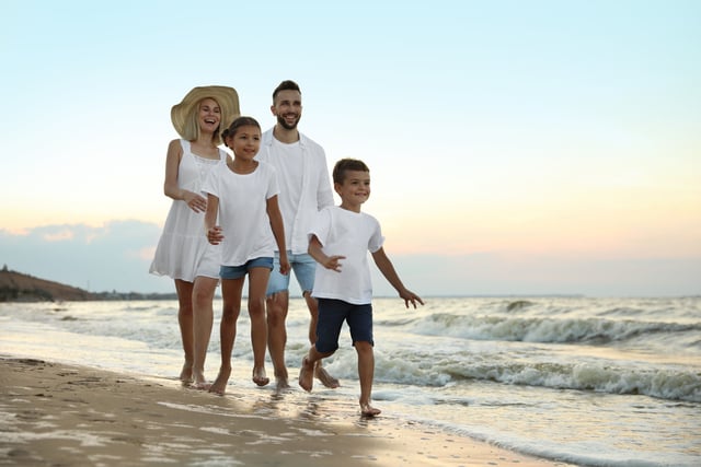 Happy family walking on sandy beach near sea at sunset https://www.vecteezy.com/photo/82208884-happy-family-walking-on-sandy-beach-near-sea-at-sunset