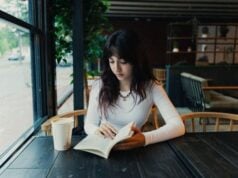 https://www.pexels.com/photo/a-woman-reading-a-book-at-a-table-with-a-cup-of-coffee-27658223/