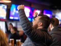https://www.vecteezy.com/photo/69539809-a-man-cheers-with-his-arms-raised-at-a-sports-bar-watching-a-game-on-the-tv-screen
