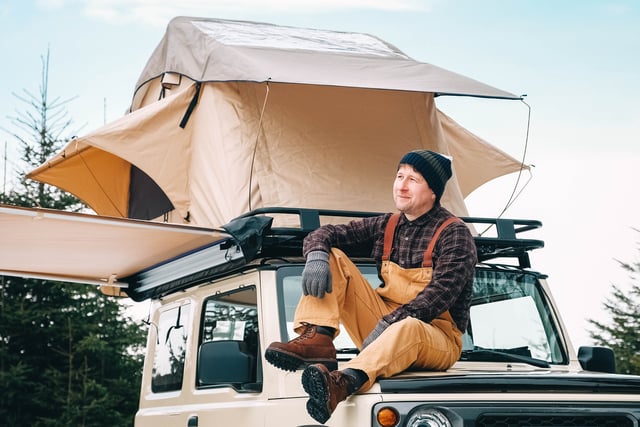 Adventurer man sitting down on roof of the car with tent mounted on it for free travel camping lifestyle https://www.vecteezy.com/photo/6865656-adventurer-man-sitting-down-on-roof-of-the-car-with-tent-mounted-on-it-for-free-travel-camping-lifestyle