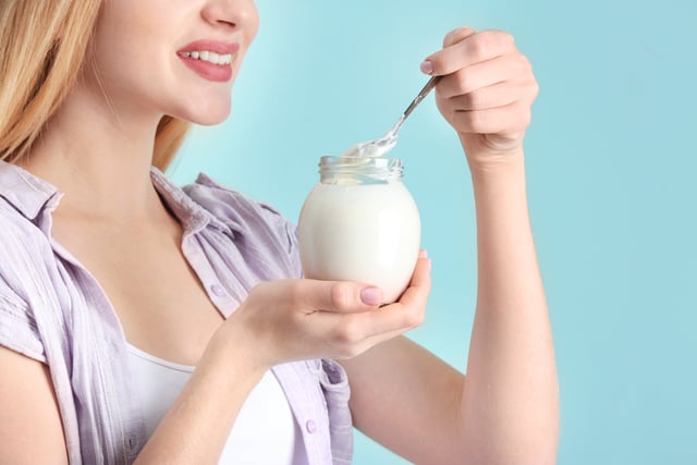 Young woman with yogurt on color background https://www.vecteezy.com/photo/87274346-young-woman-appears-in-with-yogurt-on-color-background-tropical